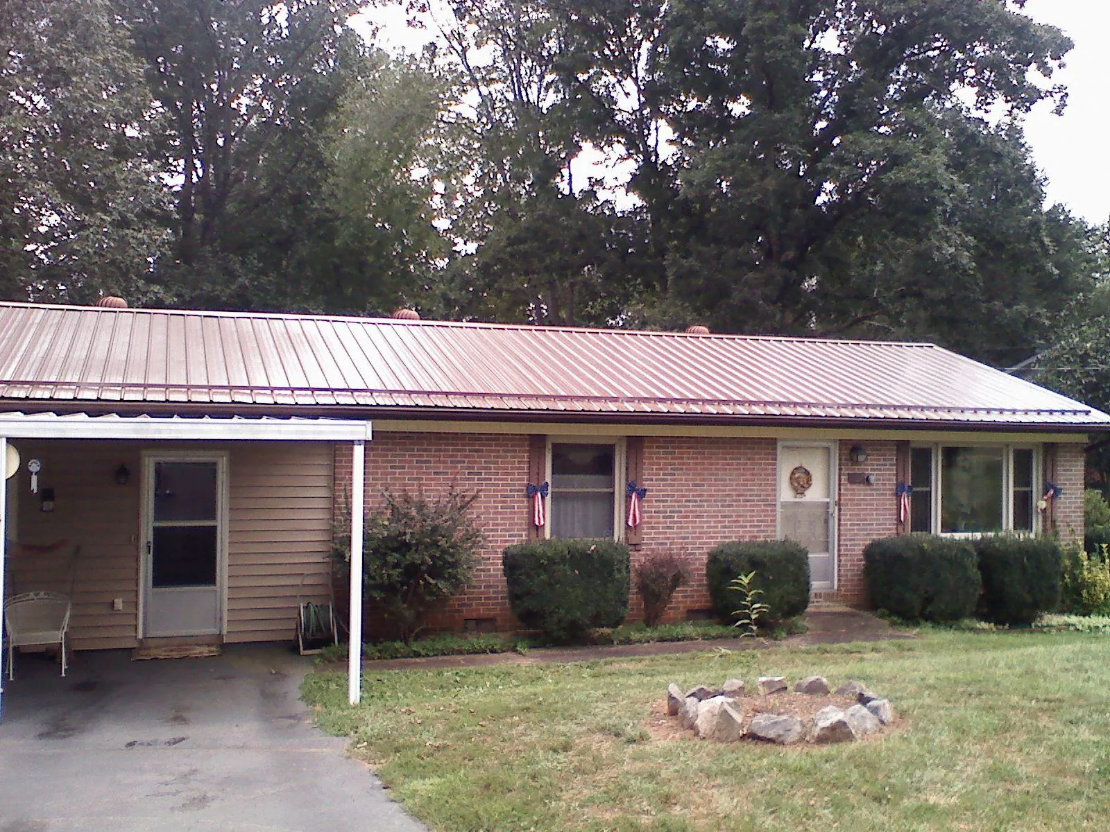 Bronze metal roof and carport on a brick ranch home — Roof Repair work by our crew in Robersonville